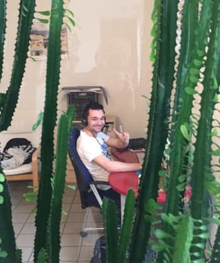 Thomas Gal at about 18 at his desk in his first office, behind cacti